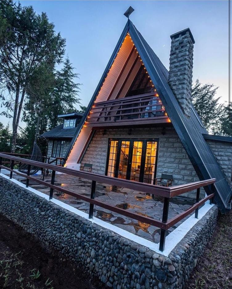 Completed stone A-frame Airbnb cabin at dusk, Nanyuki